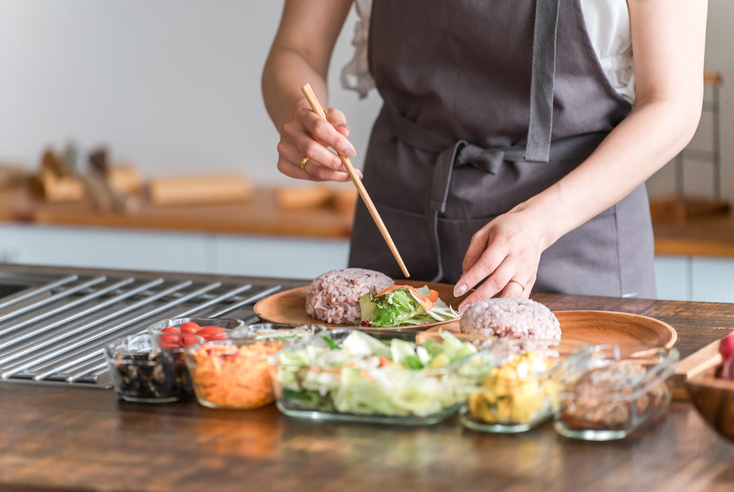 写真：健康そうな料理とそれをよそう女性の手